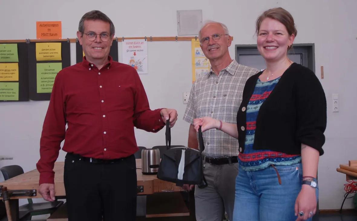 Von links: Lothar Baier, Sicherheitsingenieur E-Werk Mittelbaden, übergibt das Messgerät an Werner Bieser, freiwilliger Helfer im Repair Café, und Sofia Späth, Klimaschutz- und Klimaanpassungsmanagerin der Stadt Kehl.